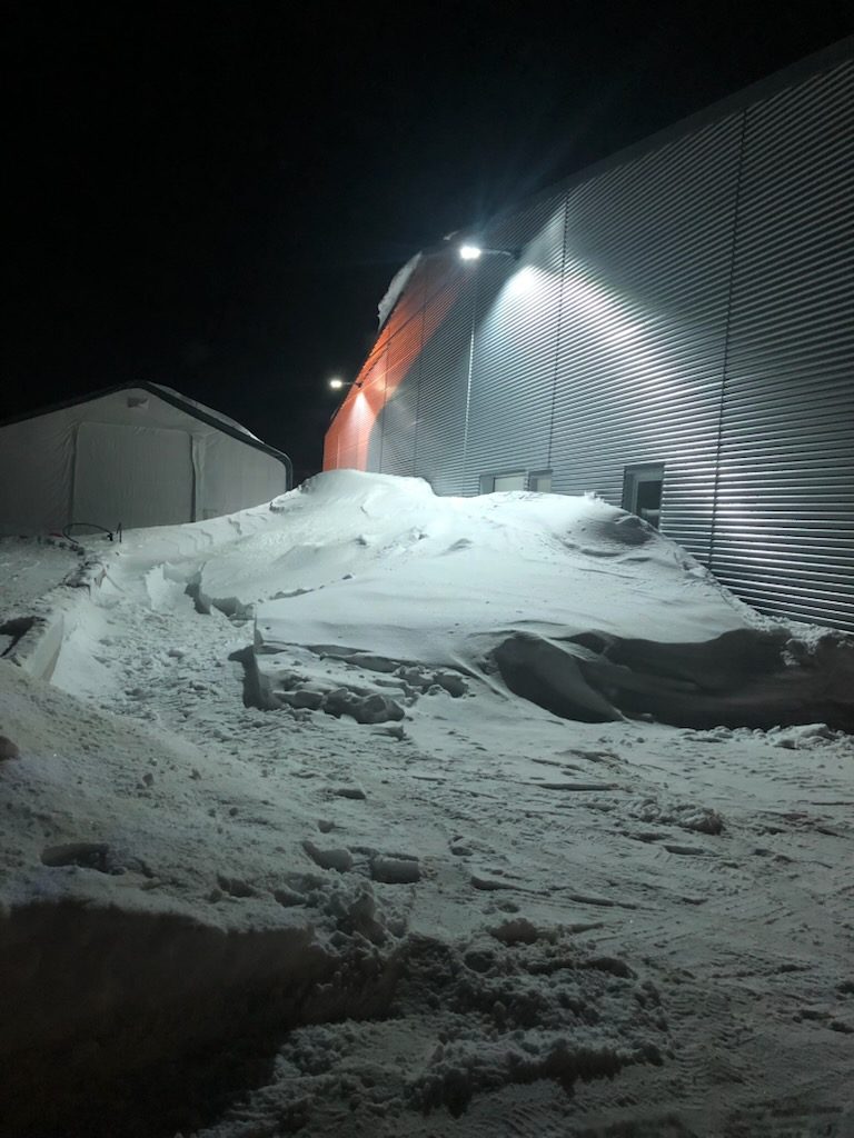 Brøytet industriområde om natten med store snøhauger